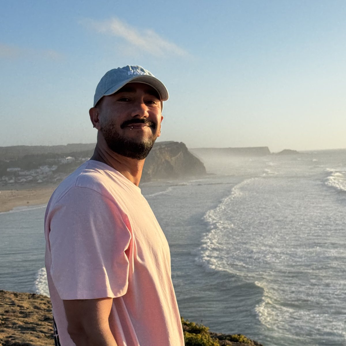 Reza Jalilpour on a cliff above the sea at sunset