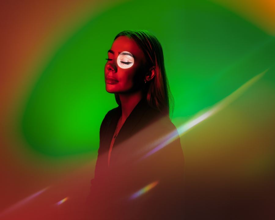 See: A red-lit face with a white disc over one eye, ringed in green