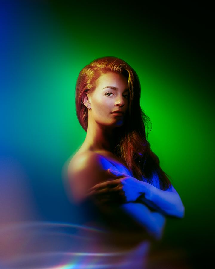 Frostbite: Red hair and crossed arms, the hands turned blue, against green