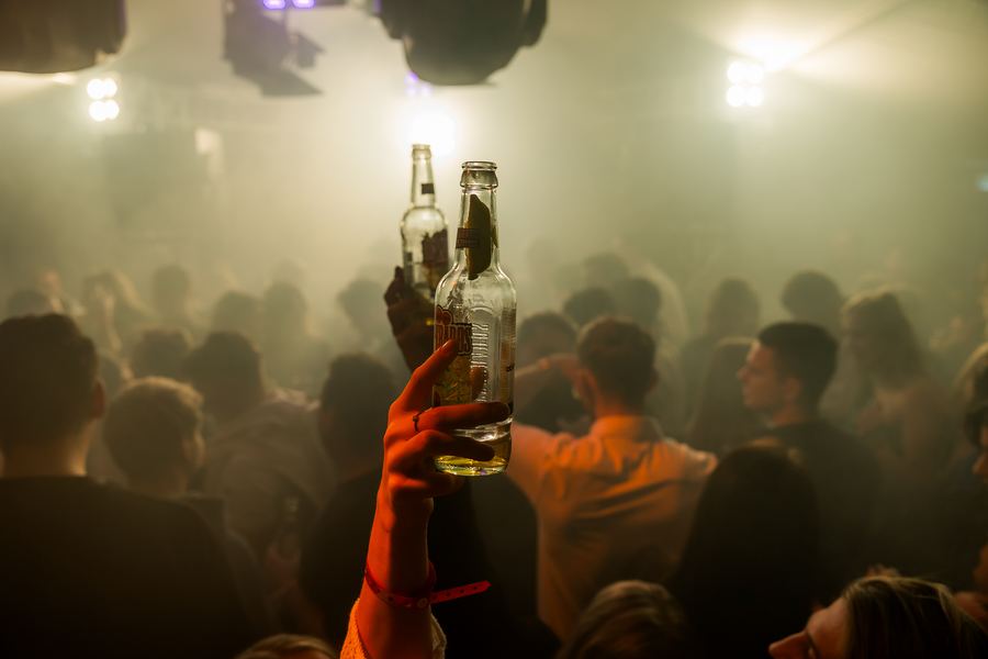 Two bottles raised in warm haze