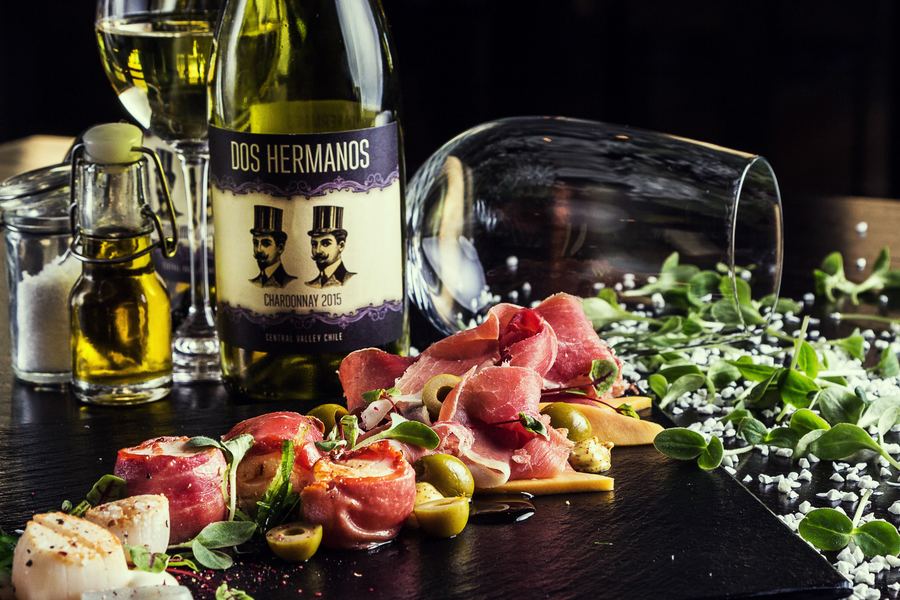 Charcuterie and scallops beside a bottle of Dos Hermanos chardonnay