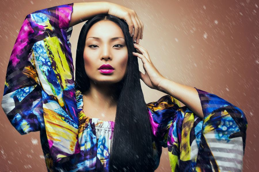 Painted-silk kimono sleeves raised around long black hair and magenta lips
