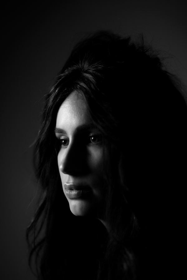 A profile emerging from shadow, in black and white