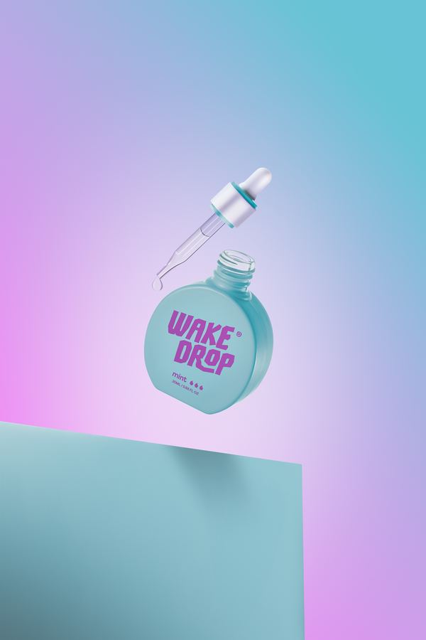 Wake Drop mint: the bottle tilted in mid-air, its pipette lifting out, on pastel