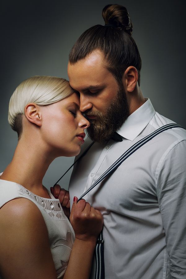 Foreheads together, her hand on his braces, in the studio
