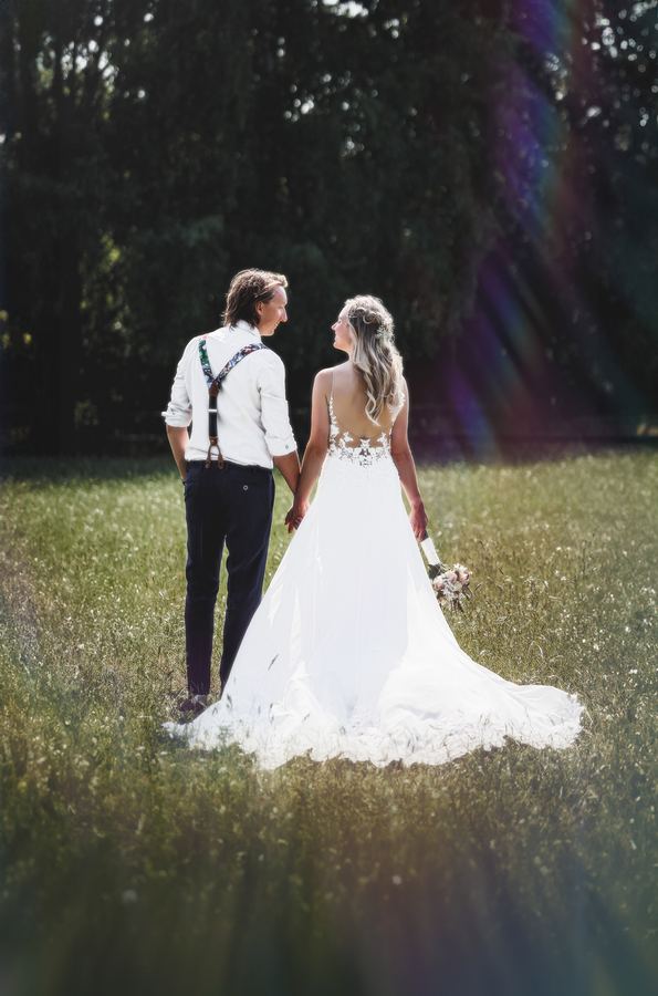 Hand in hand, walking away across the grass, the train trailing behind