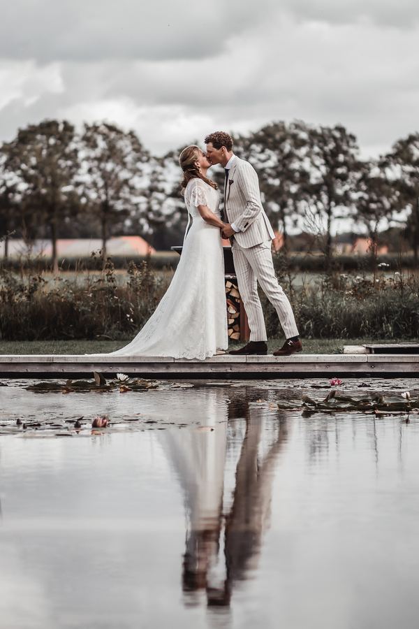 A kiss on a jetty, mirrored in the pond below